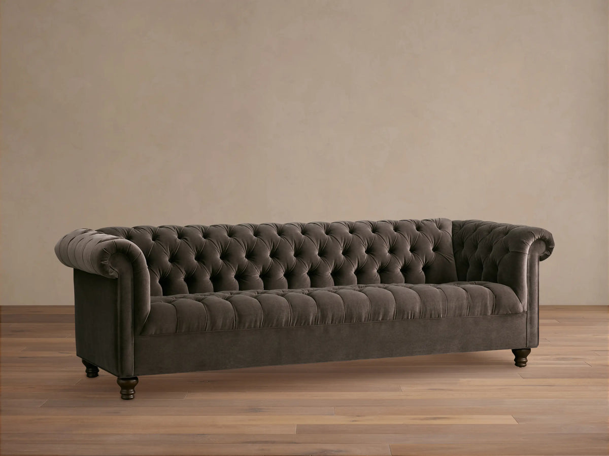 Berwick Sofa: Dark mink velvet Chesterfield sofa with deep button tufting, rolled arms, and carved wooden feet.