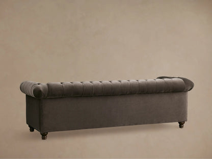 Close-up of a dark brown tufted Berwick Sofa, plush velvet texture on the deeply buttoned seat, back, and rolled arm.