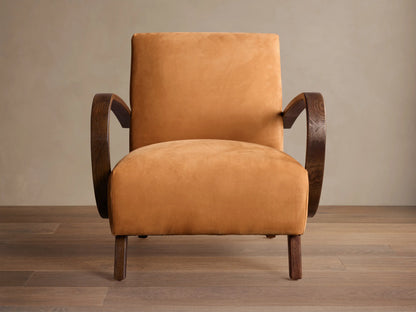 Ochre Gabel leather armchair with dark curved wood armrests and legs, angled right on a wooden floor.