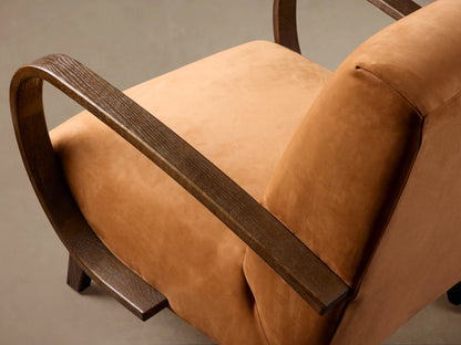Gabel Leather Chair with tan leather upholstery, dark curved wooden armrests, and dark wooden legs, on a wooden floor.