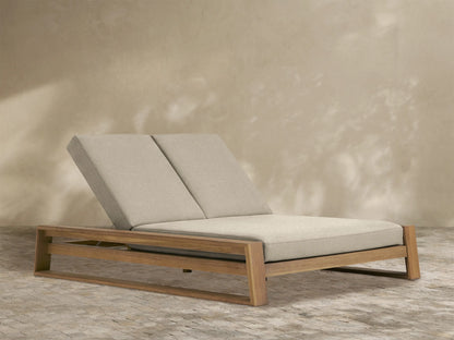 Canyon Outdoor Teak Double Chaise with two tan cushioned seats & backs, reclined upwards, on a light brown teak frame.