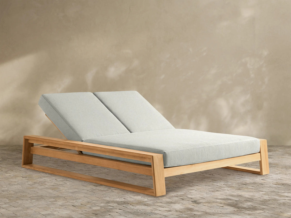 Canyon Outdoor Teak Double Chaise with natural teak wood frame and light grey cushions. Both adjustable backrests are angled up.