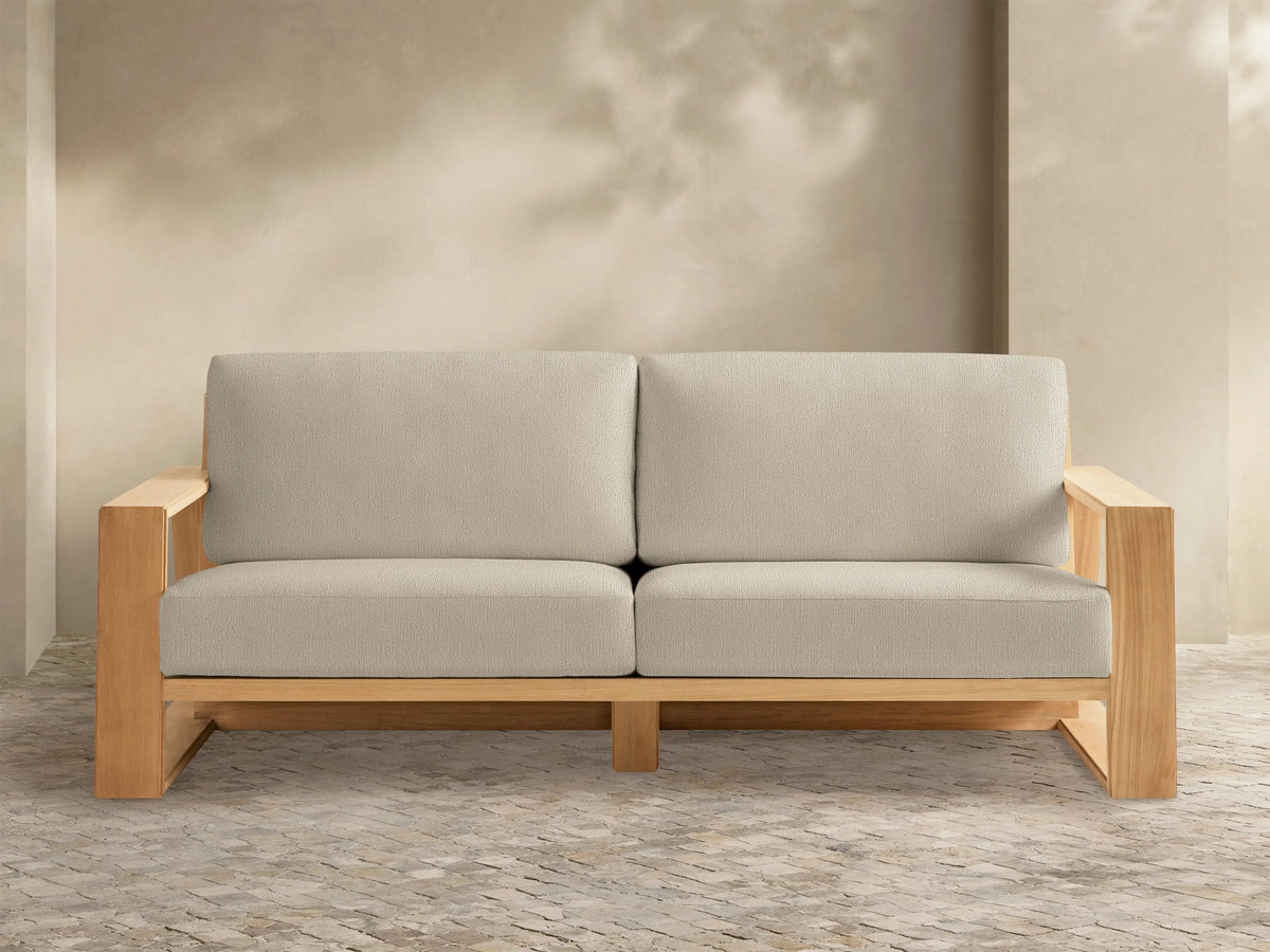 Canyon Outdoor Teak Sofa: sturdy light teak wood frame with two light beige seat & back cushions, front view.