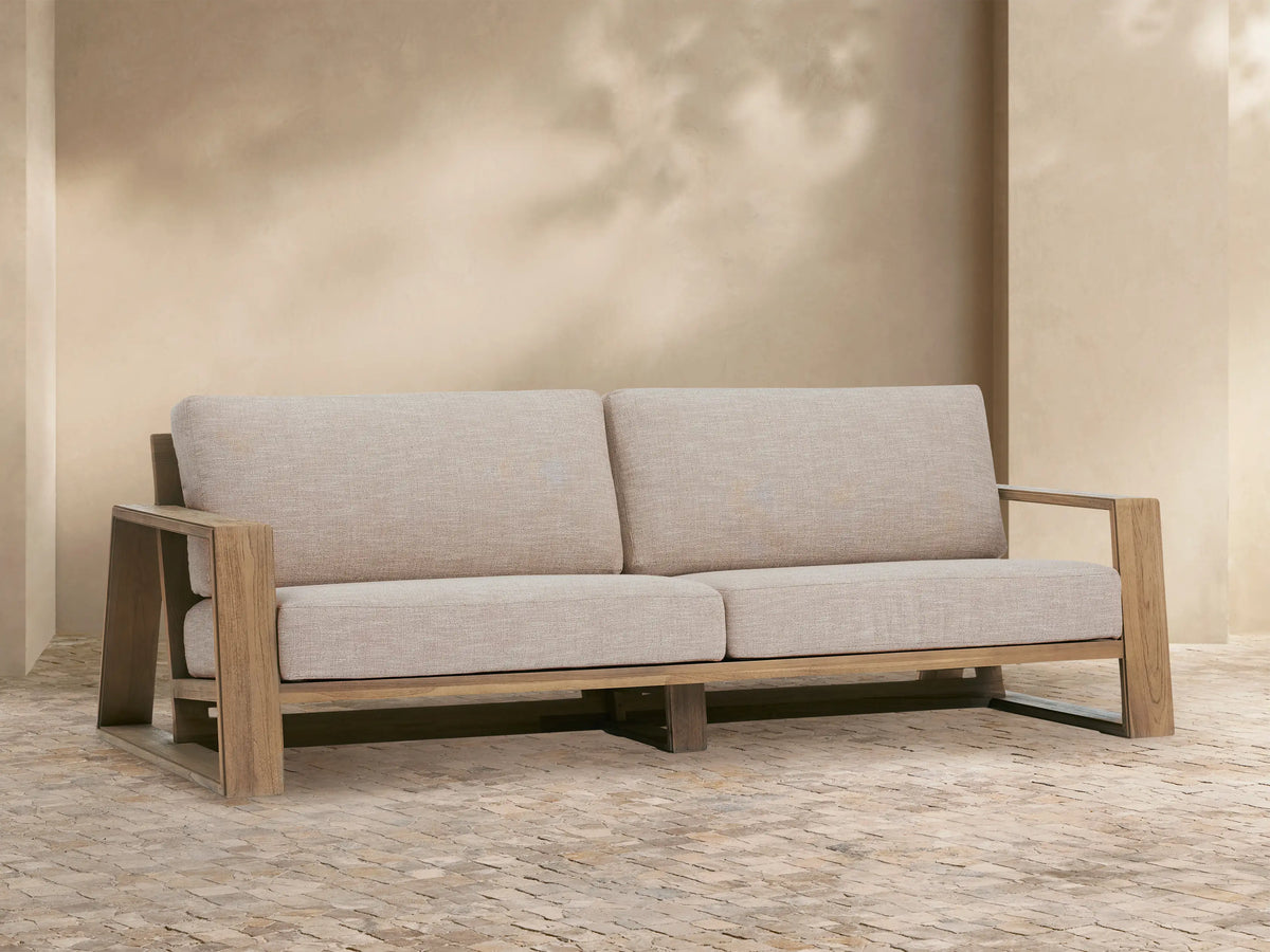 Front view of the Canyon Outdoor Teak Sofa with natural teak wood frame and light beige performance fabric cushions.