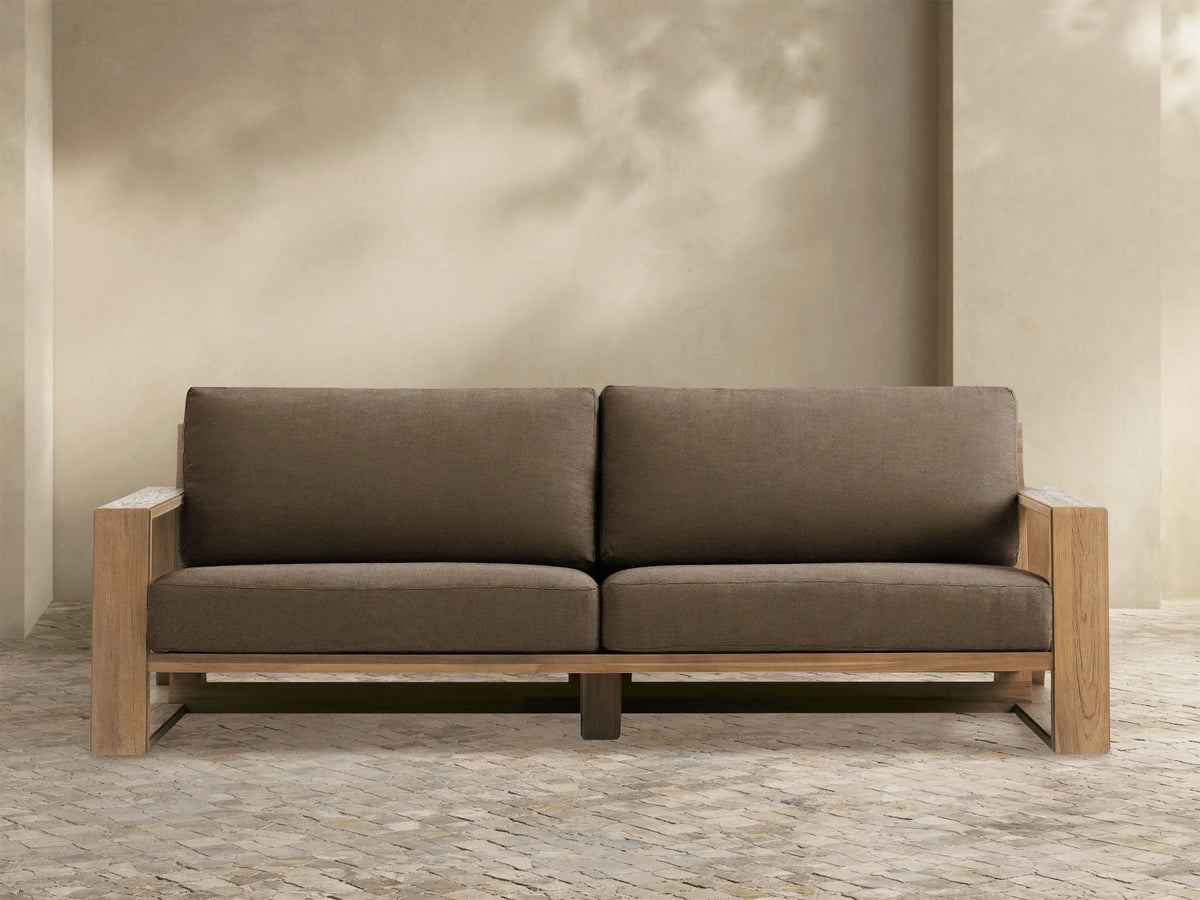Two-seater Canyon Outdoor Teak Sofa with a natural teak wood frame and dark brown cushions, viewed from the front.