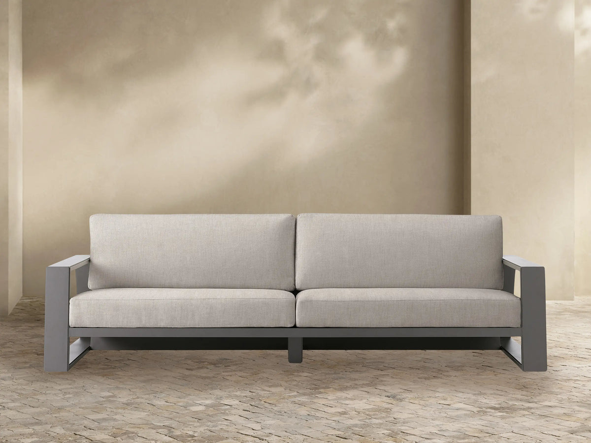 Canyon Outdoor Aluminum Sofa. Front view of a modern sofa with a dark gray aluminum frame and two light beige fabric cushions.