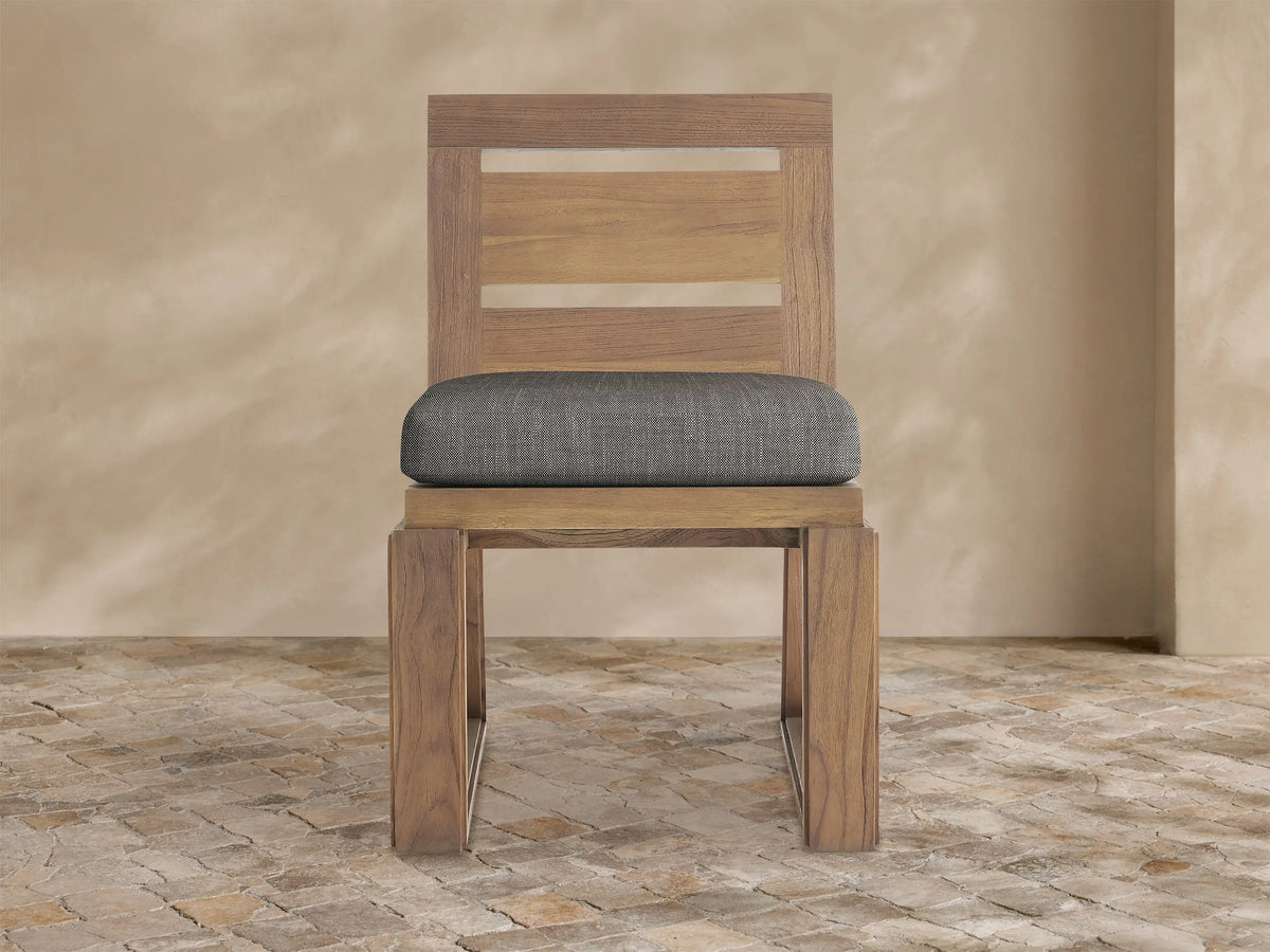 Front view of Canyon Outdoor Teak Dining Side Chair. Light brown teak wood frame with slatted back, dark gray seat cushion.