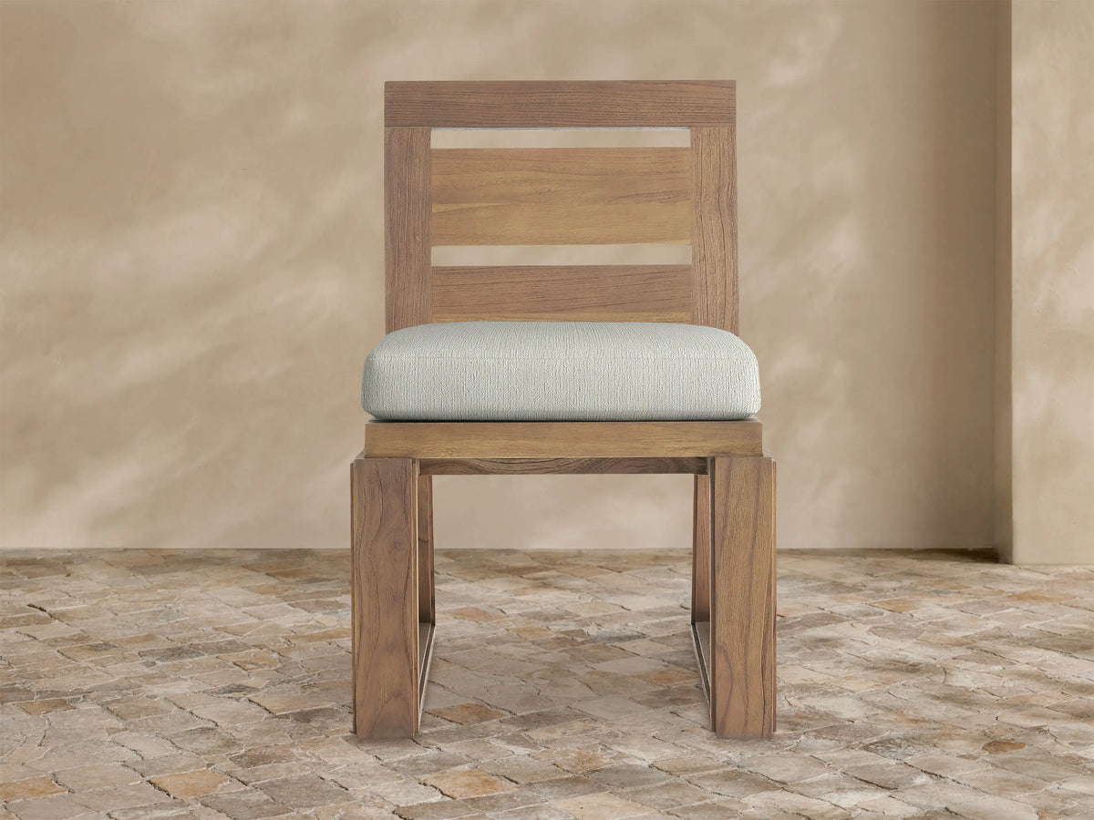 Front view of Canyon Outdoor Teak Dining Side Chair with a warm brown teak frame, slatted back, and light grey cushion.