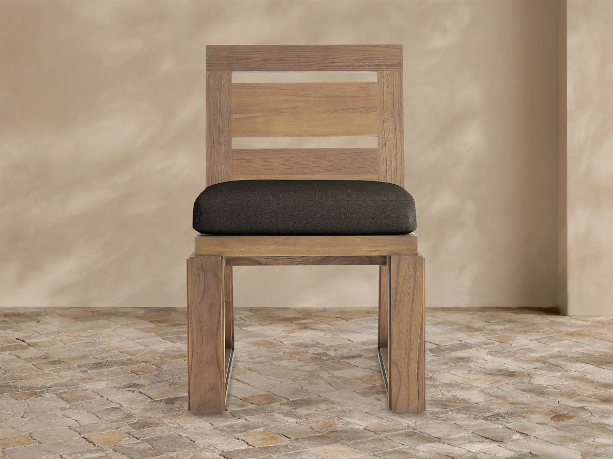 Canyon Outdoor Teak Dining Side Chair, front view. Natural teak frame with two horizontal slats, and a dark brown cushion.