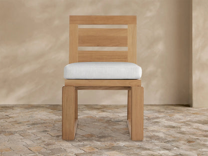 Front view of Canyon Outdoor Teak Dining Side Chair. It has a natural teak frame with two back slats & a light gray seat cushion.