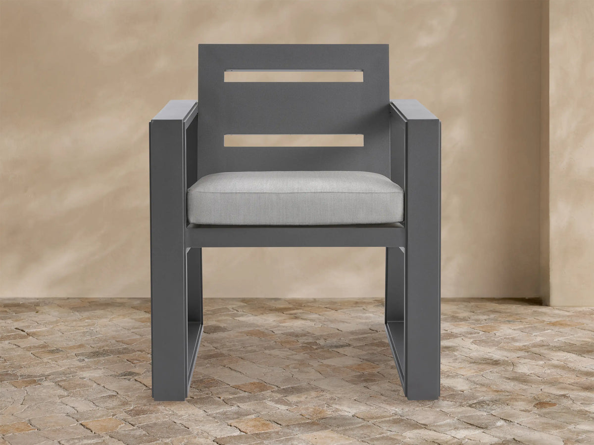 Front view of Canyon Outdoor Aluminum Dining Arm Chair. Dark gray aluminum frame with two back slats, light gray cushion.