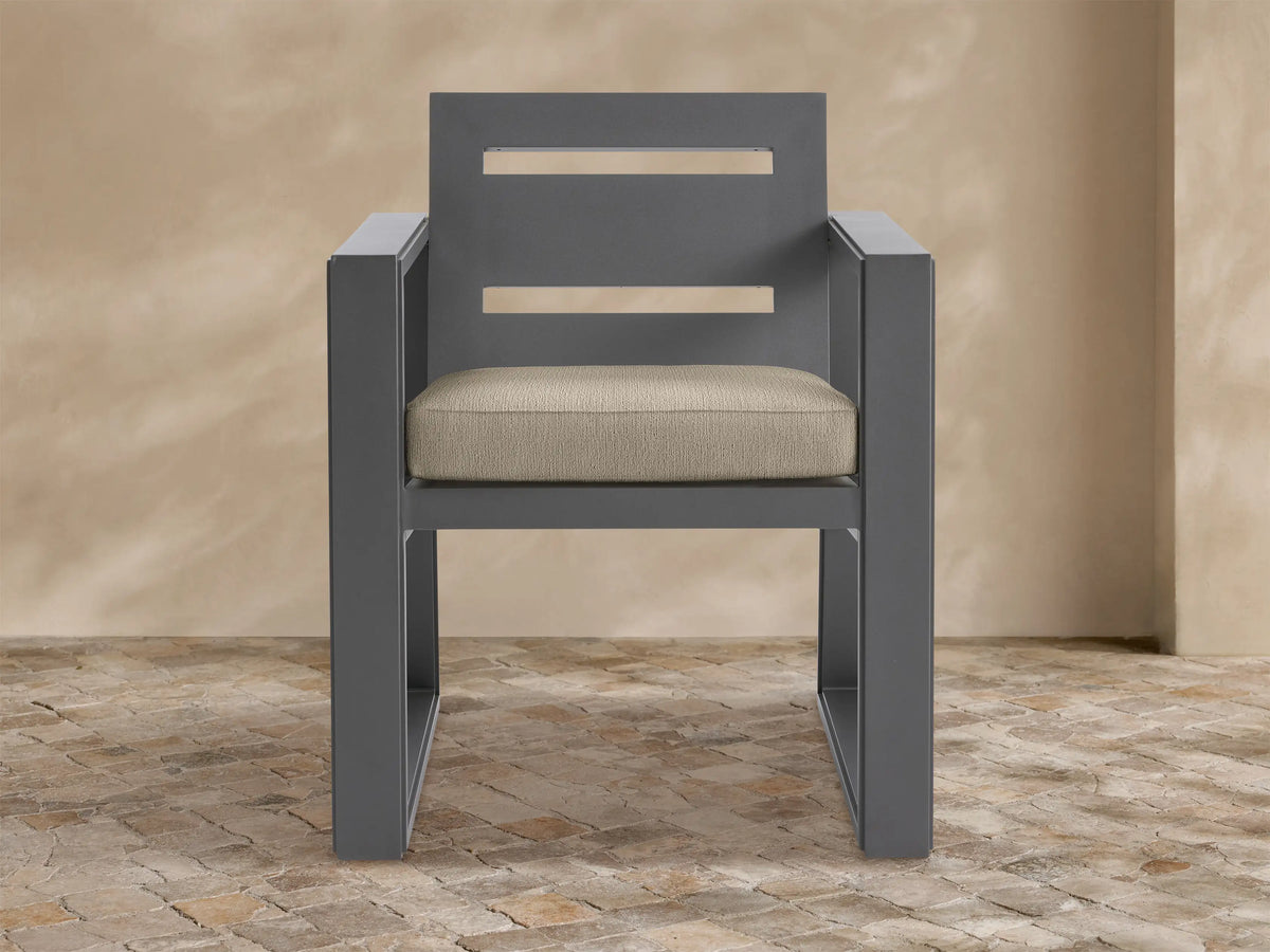 Front view of Canyon Outdoor Aluminum Dining Arm Chair. Charcoal gray aluminum frame with slatted back and light beige cushion.
