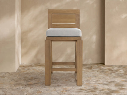 Canyon Outdoor Teak Barstool, front view. Natural teak wood frame with slatted backrest & light grey seat cushion.