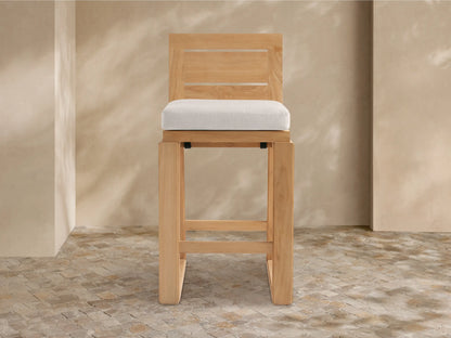 Front view of Canyon Outdoor Teak Barstool, natural teak wood with slatted back, square frame, and light grey cushion.