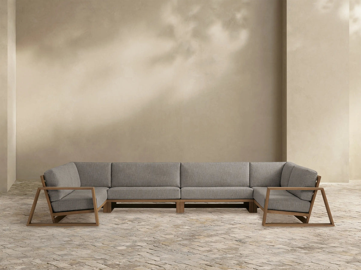 Canyon Outdoor Teak Four-Piece Sectional, L-shaped, with Weathered Fawn teak frame and light grey cushions.