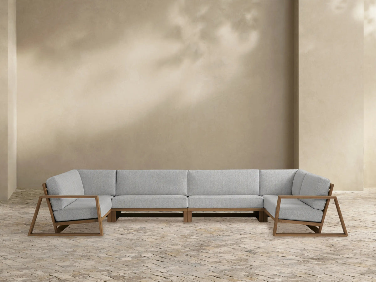 Canyon Outdoor Teak Four-Piece Sectional with light grey cushions & an L-shaped weathered fawn teak frame, open armrests.