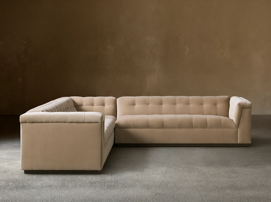 L-shaped Cameran Three-Piece Sectional sofa in light beige, with square-tufted backrests, on a wooden floor against a beige wall.