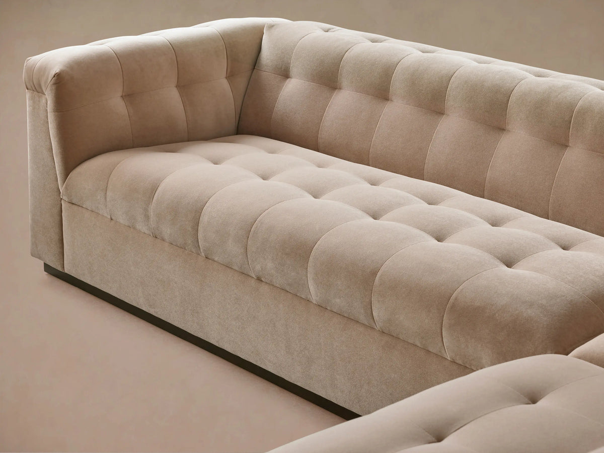 Cameran Three-Piece Sectional sofa, L-shaped, in light beige plush fabric with tufted backrests & rolled arms, on wood floor.