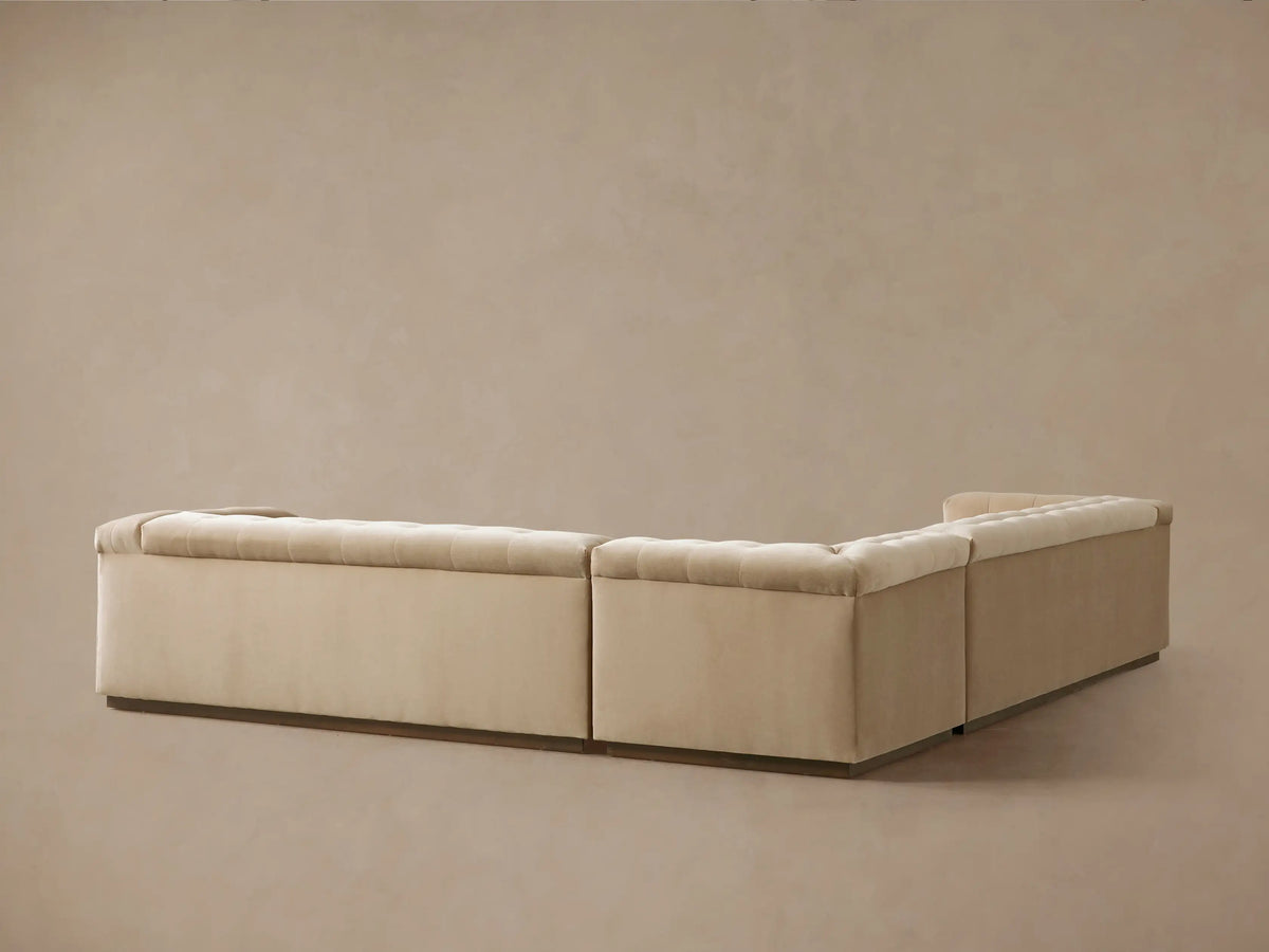 Angled view of a light beige Cameran Three-Piece Sectional, with soft, button-tufted seats & back.