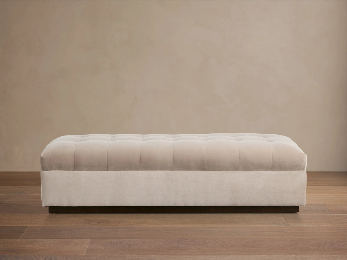 Cameran Bench in a soft beige fabric, featuring tufted detailing on the seat, set against a neutral wall and wooden floor.