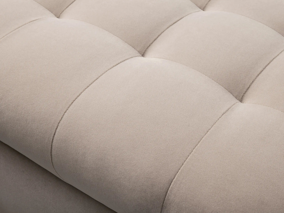 A beige Cameran Bench with a tufted seat and smooth sides, placed on a wooden floor against a neutral wall.