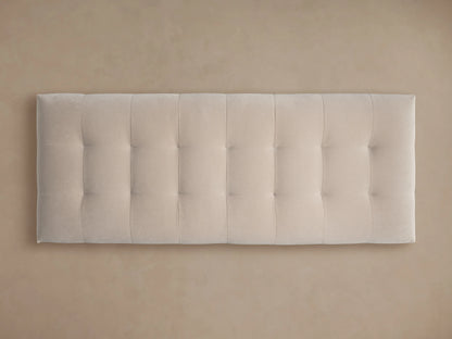 Cameran Bench, a light beige, tufted upholstered bench with a dark base, on a hardwood floor against a neutral wall.