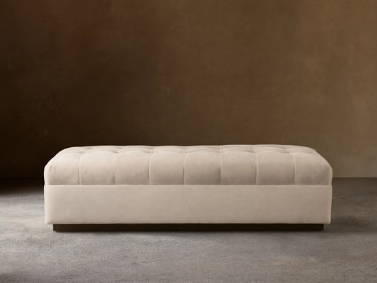 Cameran Bench in a soft beige fabric, featuring tufted detailing on the seat, set against a neutral wall and wooden floor.