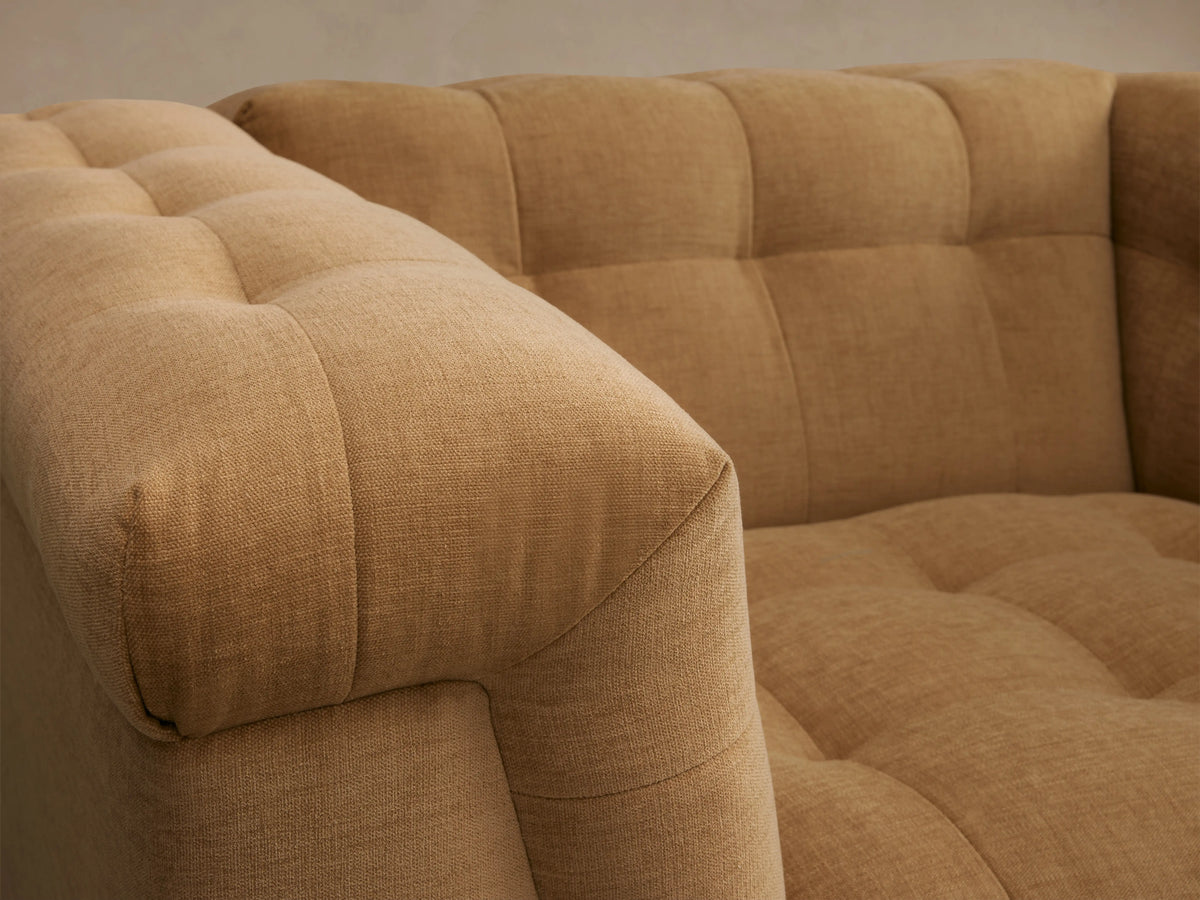 Cameran Chair in warm beige fabric, tufted design, plush armrests, and cushioned backrest, on wooden floor, neutral background.