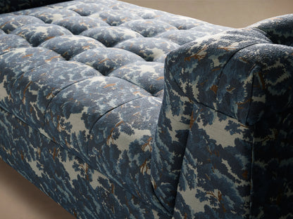 Cameran Daybed with a tufted blue and white floral pattern, featuring cushioned backrests on both ends and a wooden base.