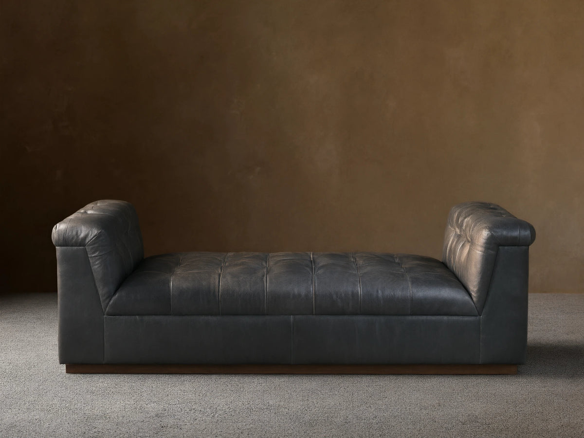 Front view of the Slate Cameran Leather Daybed with a tufted seat and integrated tufted armrests.