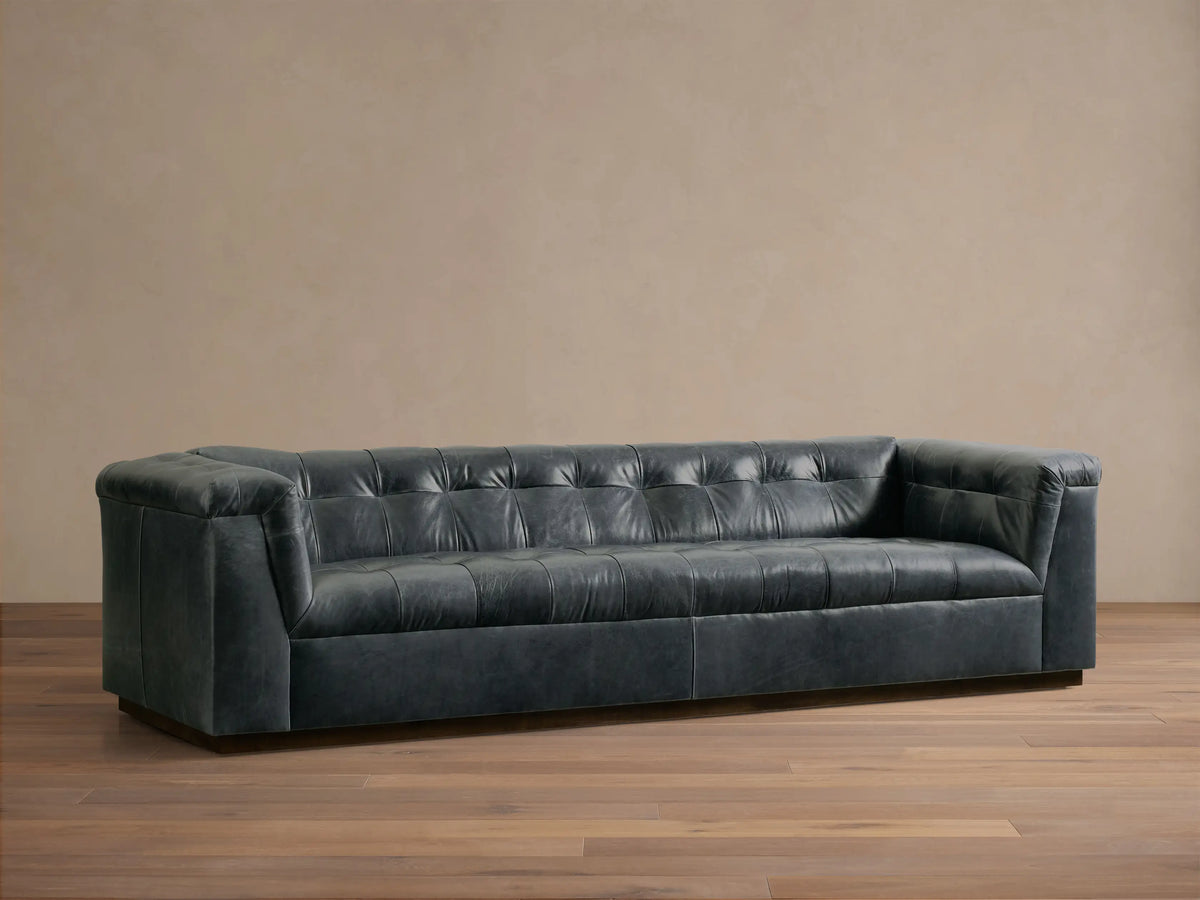 Rear view of the dark gray Cameran Leather Sofa, featuring a tufted top edge and smooth, paneled back.