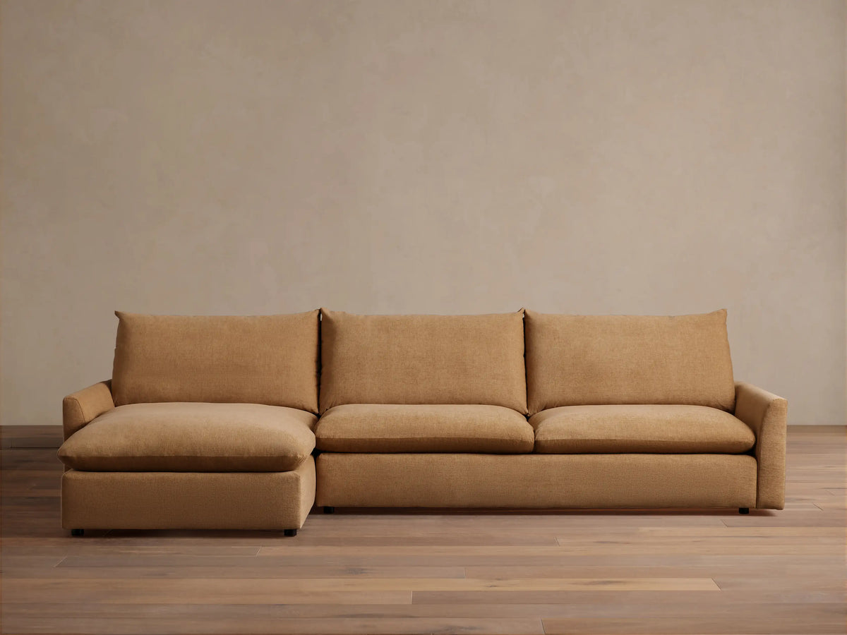 The Calistoga Two-Piece Chaise Sectional in tan fabric, featuring a left-side chaise and three-seat design, shown in a minimalist room.