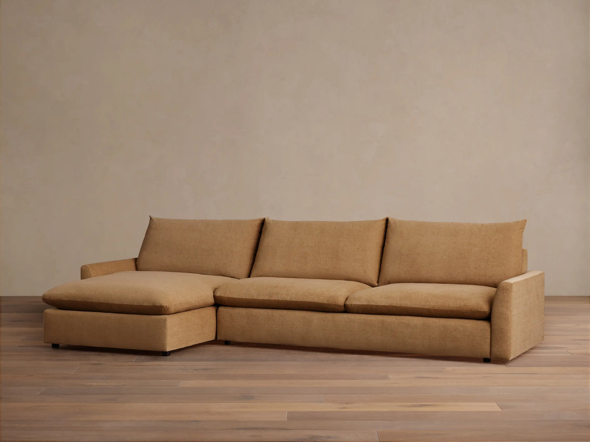 The Calistoga Two-Piece Chaise Sectional in tan fabric, featuring a left-side chaise and three-seat design, shown in a minimalist room.
