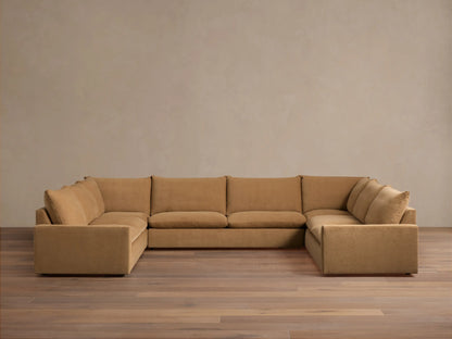 Five-piece sectional sofa in tan fabric, set in a spacious room, featuring a casual design with slight fabric wrinkles.