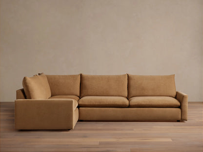 Calistoga Two-Piece Sectional in a light brown fabric. L-shaped design with plush cushions, set on a wooden floor against a neutral wall.