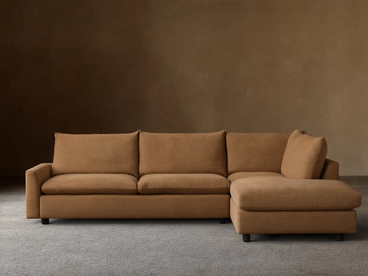 Calistoga Two-Piece Sectional in a light brown fabric. L-shaped design with plush cushions, set on a wooden floor against a neutral wall.