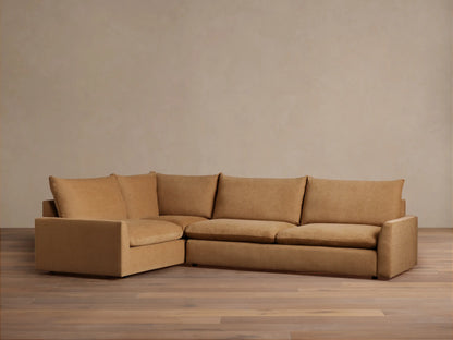 Calistoga Two-Piece Sectional in a light brown fabric. L-shaped design with plush cushions, set on a wooden floor against a neutral wall.