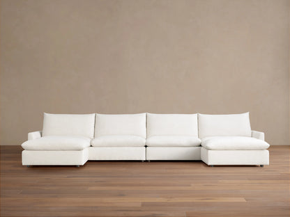 Calistoga Four-Piece Sectional in off-white, with left and right chaises, against a neutral brown wall and wood floor.