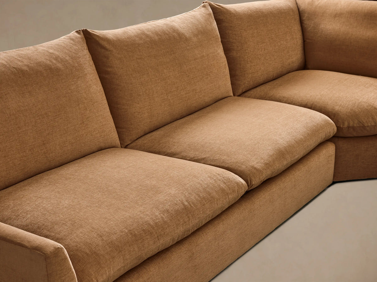 Corner view of the Tan Calistoga Three-Piece Corner Wedge Sectional, highlighting its plush seat and back cushions.