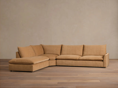 Front view of a tan Calistoga Three-Piece Bumper Sectional, showcasing its plush, relaxed design with a deep chaise lounge.