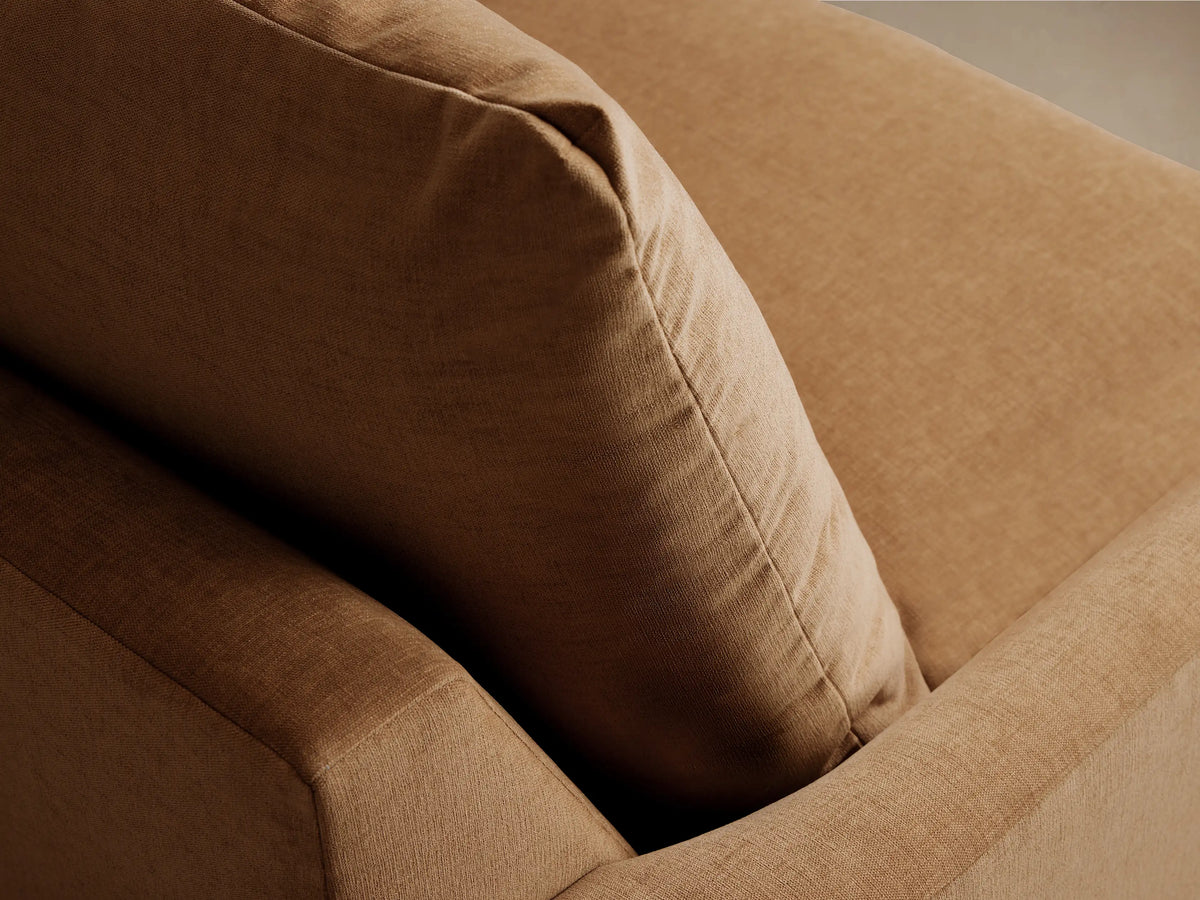Calistoga Chair in tan fabric, featuring plush seat and back cushions with soft, wide armrests, set on wooden floor.