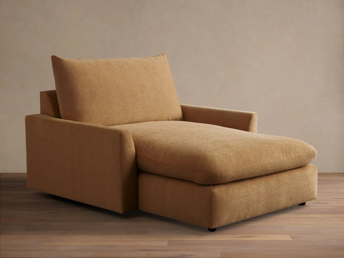 Angled front view of the tan Calistoga Chaise, featuring a wide seat and plump back cushion.