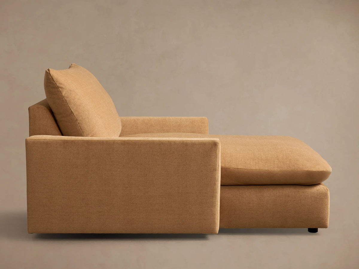 Angled front view of the tan Calistoga Chaise, featuring a wide seat and plump back cushion.