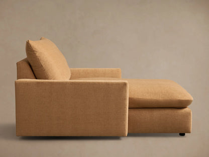 Angled front view of the tan Calistoga Chaise, featuring a wide seat and plump back cushion.