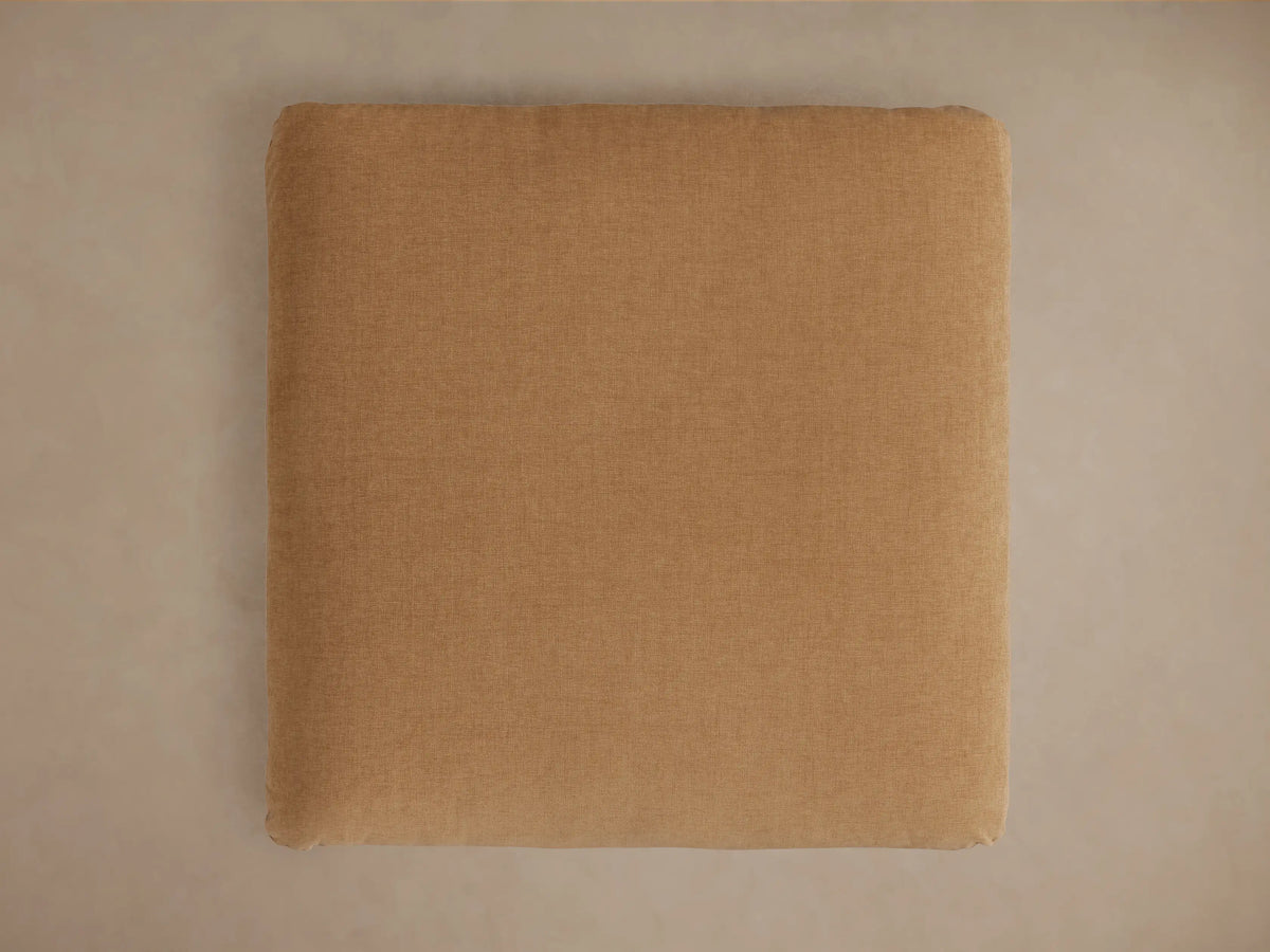 Calistoga Ottoman in a soft brown fabric, showing its smooth, slightly textured surface with a casual, relaxed look.