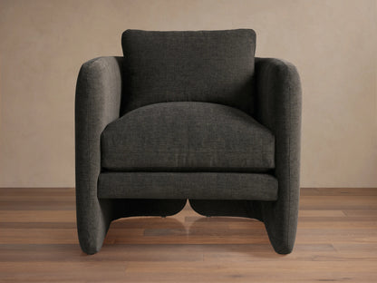 Front view of the Dalia Chair, a modern dark charcoal gray upholstered accent chair with soft lines on wood floor.
