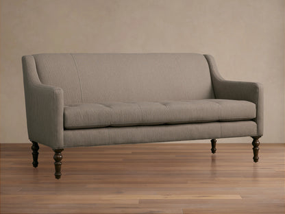 Fenwick Settee: Light beige settee with thin dark vertical stripes, tufted seat, sloped arms, dark turned wood legs, and nailhead trim.