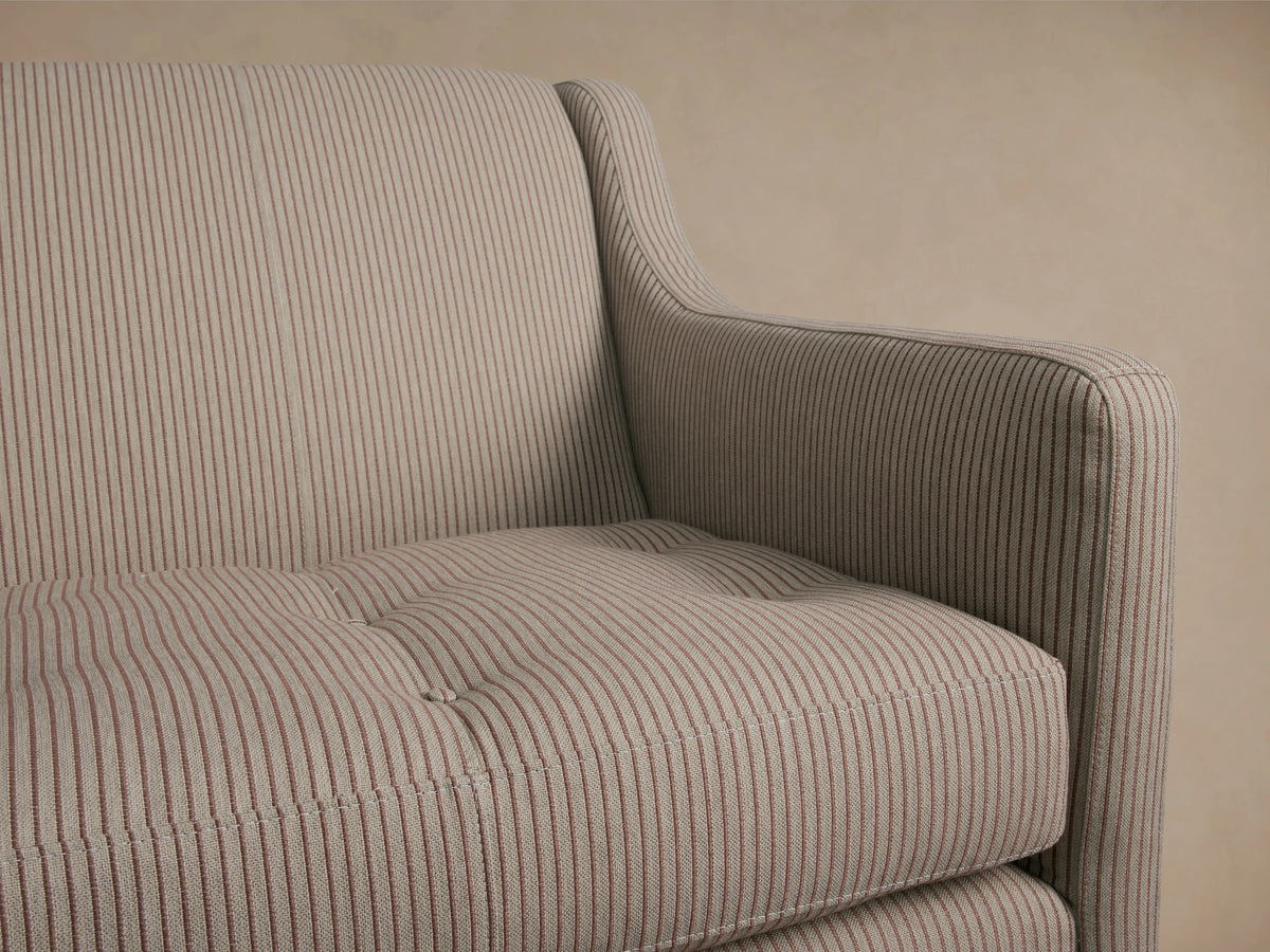 Fenwick Settee, rear-left view. Gray striped fabric, dark turned wood legs. Neutral background.