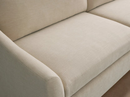 Light beige Helena Sofa with textured fabric, showing a rounded armrest, plush seat, and back cushions from an angled view.