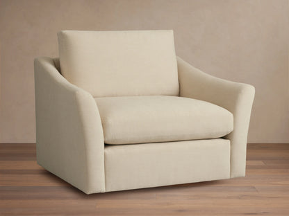 Helena Swivel Chair in beige fabric, features gently curved armrests and a cushioned seat and backrest on a wooden floor background.